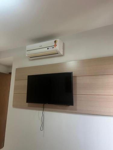a flat screen tv sitting on top of a shelf at Apartamentos em Rio Quente com maravilhosa área de lazer e excelente localização in Rio Quente