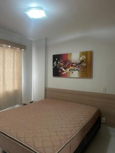 a bedroom with a bed and a painting on the wall at Apartamentos em Rio Quente com maravilhosa área de lazer e excelente localização in Rio Quente