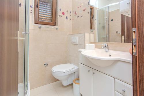 a bathroom with a toilet and a sink and a shower at Family friendly house with a parking space Privlaka, Zadar - 23633 in Privlaka