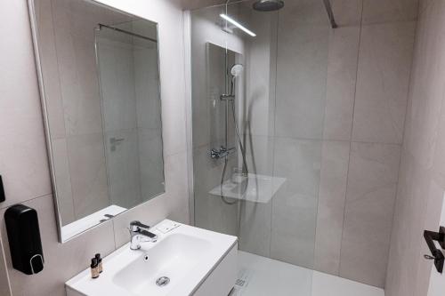 a white bathroom with a shower and a sink at Complex Turistic Capus & Spa in Căpuşu Mare