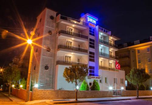 a hotel with a sign on top of it at night at Şirin Apartrooms in Pamukkale