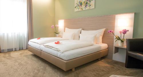 a bedroom with a large bed with flowers on it at Hotel Raffel in Jennersdorf