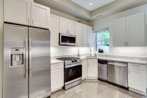 una cucina con armadietti bianchi ed elettrodomestici in acciaio inossidabile di Modern 1 block from Metro subway Minutes to Capital, Museums and National Mall a Washington
