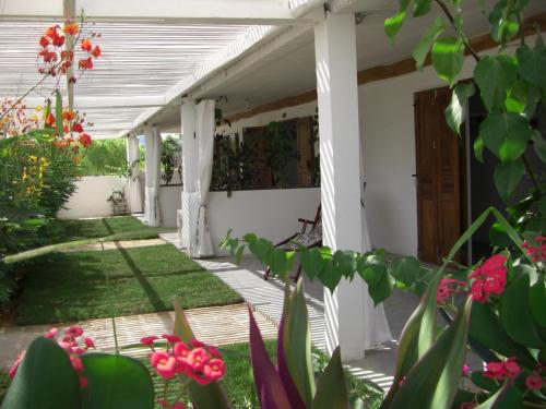 a porch of a house with flowers in the yard at Le Jardin de L'isle in Ifaty