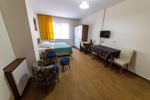 a hotel room with a bed and a desk and chairs at Şirin Apartrooms in Pamukkale