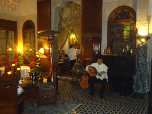 a man sitting in a room playing a guitar at Riad Arabesque & Spa in Fès
