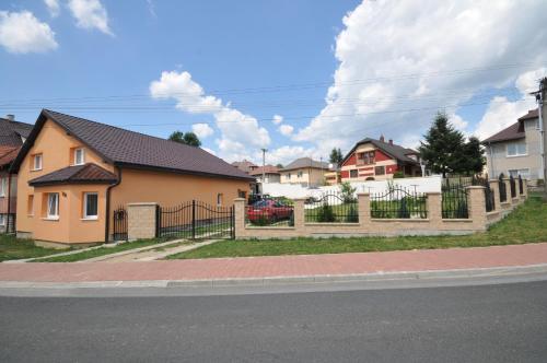 a house with a fence on the side of a street at Superubytovanie Olga in Štrba