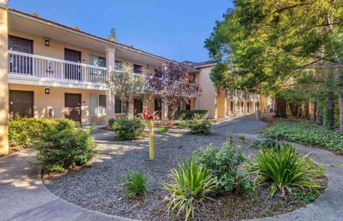 an apartment building with a courtyard with plants at Extended Stay America Suites - San Jose - Mountain View in Mountain View