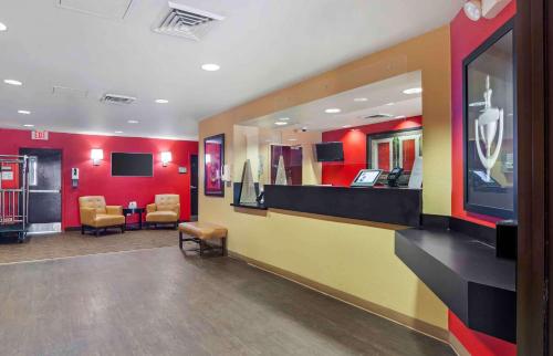a lobby with a waiting room with chairs and red walls at Extended Stay America Suites - Palm Springs - Airport in Palm Springs