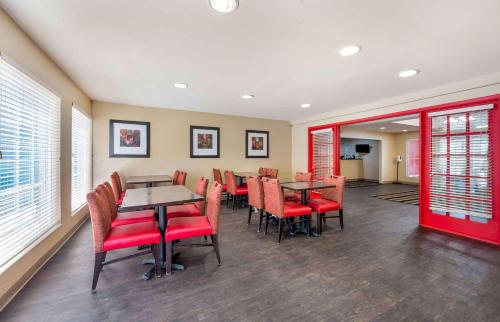 een eetkamer met tafels en rode stoelen bij Extended Stay America Suites - Indianapolis - West 86th St in Indianapolis