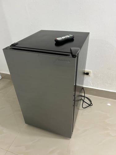 un mando a distancia sentado en la parte superior de una nevera en Hannabi Beach Hotel, en Boca Chica