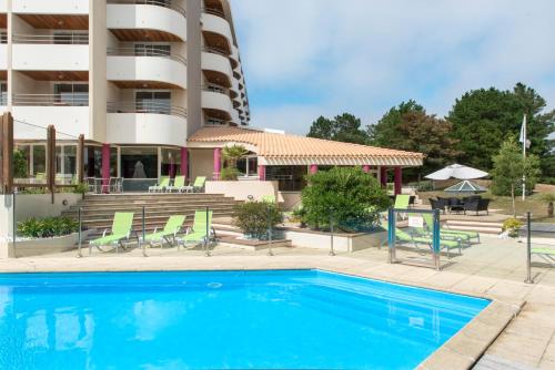 a swimming pool in front of a hotel at Résidence Valdys Thalasso & Spa - les Pins in Saint-Jean-de-Monts