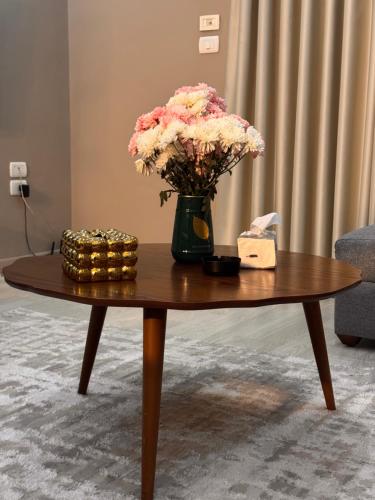 a vase of flowers sitting on a coffee table at Luxury - 2 Bedroom Apartment B7 in Madinaty