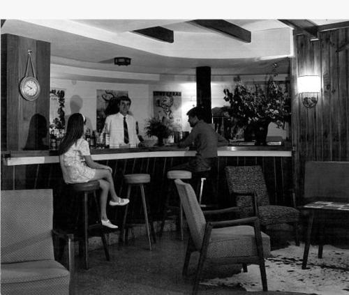 a man and a woman sitting at a bar at Hotel La Cumbrecita in La Cumbrecita