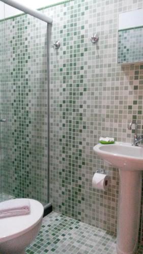 a bathroom with a sink and a toilet and a shower at Pousada Melodia do Mar in Cabo Frio
