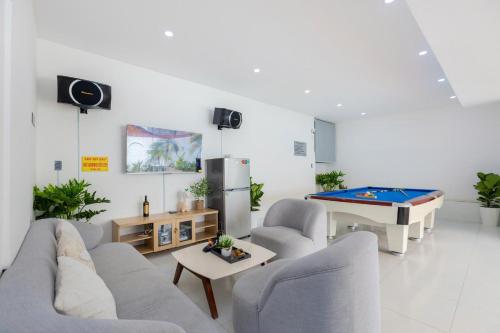 ブンタウにあるOCEAN HOUSE - Đi Bộ 100 Met Ra Biển Bãi Sau Thùy Vânのリビングルーム(ソファ、ビリヤード台付)