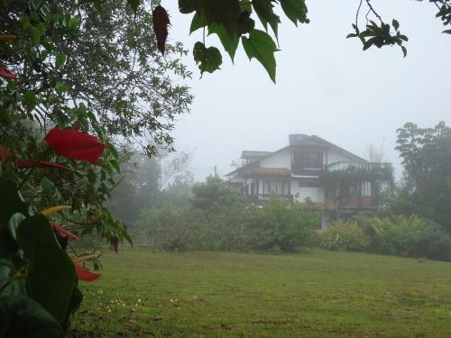 a house in the fog in front of a yard at Hostal Pachamama in San Agustín