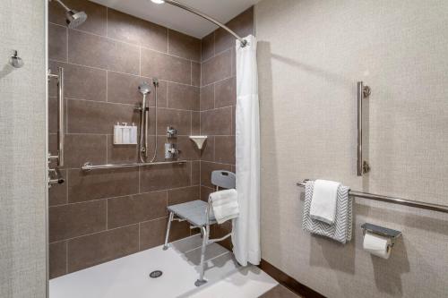 a bathroom with a shower and a chair in it at Cambria Hotel Pigeon Forge in Pigeon Forge