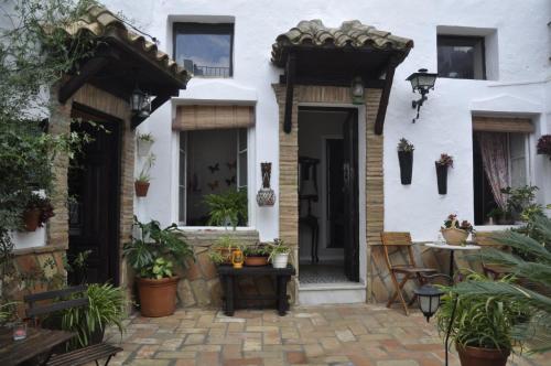 Biały dom z dziedzińcem z doniczkami w obiekcie Casa Andrea w mieście Vejer de la Frontera