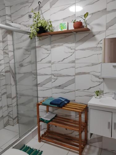 a bathroom with a bench and a marble wall at Projeto FZ Hospedagem in Salvador