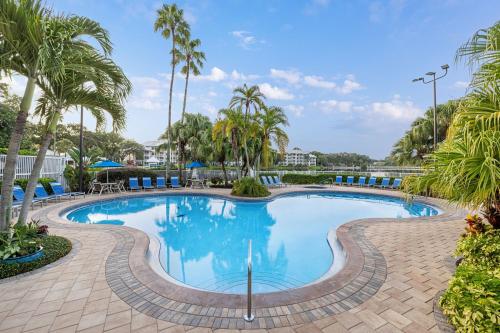 a swimming pool with palm trees in a resort at Marriott's Cypress Harbour Villas in Orlando