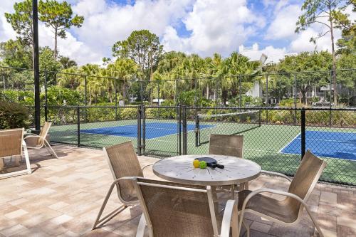 a patio with a table and chairs and a swimming pool at Marriott's Cypress Harbour Villas in Orlando