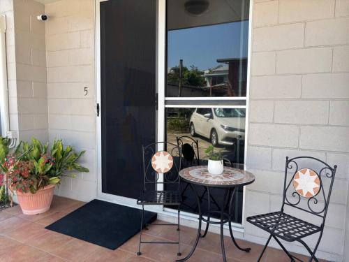 a patio with a table and chairs next to a door at Tropical Ground-Floor Retreat Cairns in Cairns North