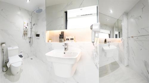 a white bathroom with a sink and a toilet at indigo Hotel Hatyai in Ban Kohong