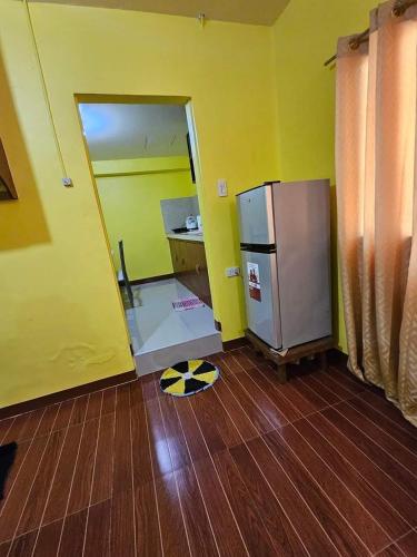 an empty kitchen with a refrigerator and a wooden floor at Casa Celine Dumaguete in Dumaguete