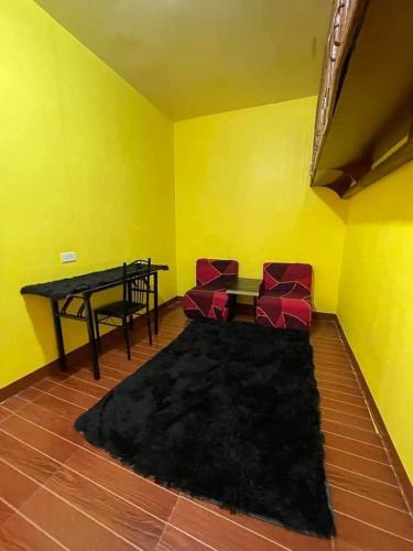 a living room with a table and two red chairs at Casa Celine Dumaguete in Dumaguete