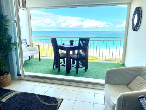 a living room with a table and chairs on a balcony at Excellence Suites Orient Beach Oceanview King-Size Beach Pool Parking in Cul de Sac