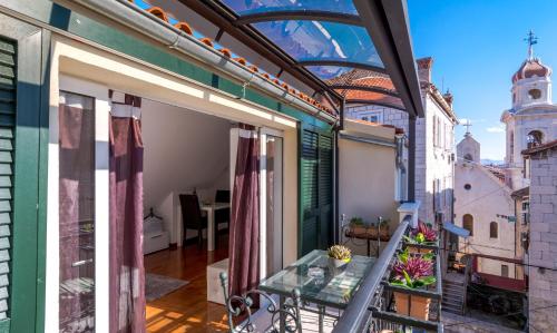 a balcony with a glass table on a building at Apartments and Rooms Villa Erede in Split