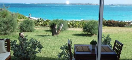 a view of the ocean from a patio with a table at Excellence Suites Orient Beach Oceanview King-Size Beach Pool Parking in Cul de Sac