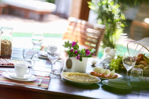 a table with a plate of food and wine glasses at Villa Métisse in Jericoacoara