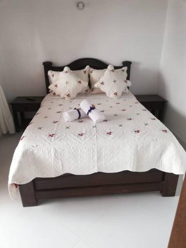 a bed with a stuffed animal laying on it at Apartamento Cemandy in Villa de Leyva