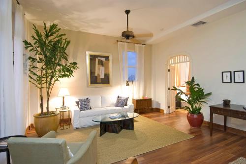 uma sala de estar com um sofá branco e uma árvore em Las Clementinas em Cidade do Panamá