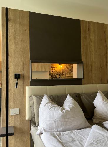 a bedroom with a mirror above a bed with white pillows at Maso Valèr - Agritur in Tassullo