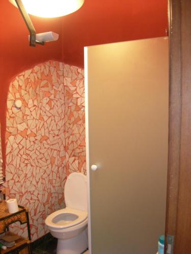 a bathroom with a toilet and a stone wall at Casa Rea in Beverino