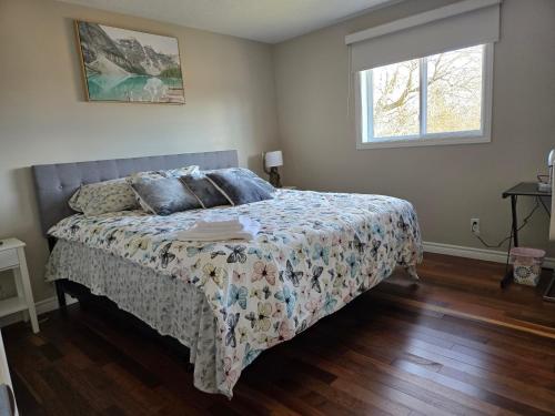 a bedroom with a bed with a comforter and a window at Beautiful House 2 bedroom in Belleville