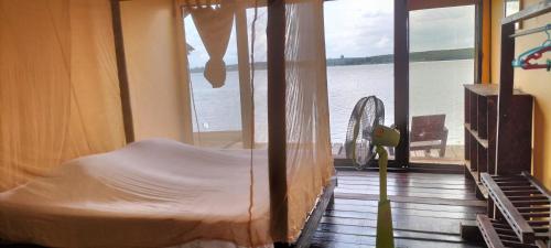 a bed in a room with a view of the water at Shamballa Dok krai in Ban Chak Man Thet