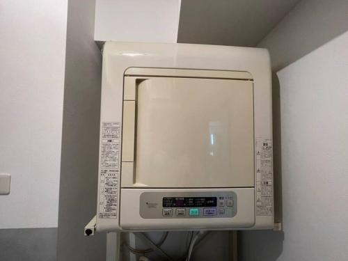 a microwave oven in a room with a wall at UNITED GARDEN hotel 2 in Utsunomiya