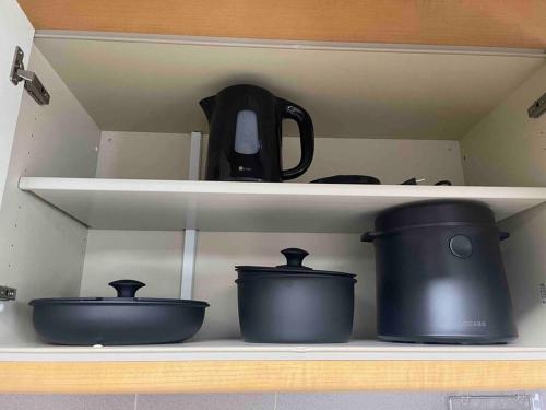 two pots and pans on a shelf in a kitchen at UNITED GARDEN hotel 2 in Utsunomiya