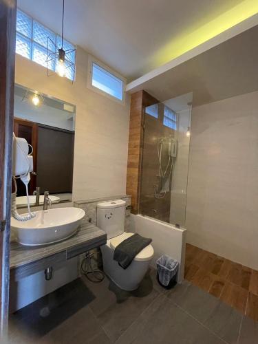 a bathroom with a sink and a toilet and a shower at Lanta Corsica Hotel in Ko Lanta