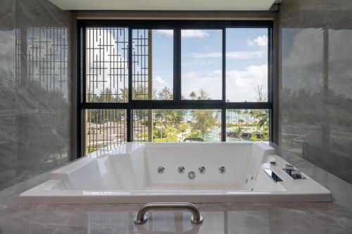 拉古洼Four Points by Sheraton Bintan, Lagoi Bay的带大窗户的浴室里的浴缸
