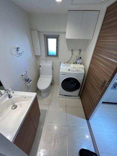 a small bathroom with a toilet and a sink at NIYS apartments 55 type in Tokyo
