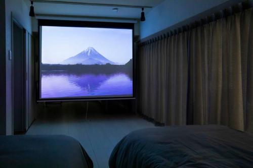 a room with a large screen with a mountain on it at NIYS apartments 55 type in Tokyo