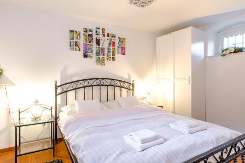 a bedroom with a white bed with two towels on it at Apartments and Rooms Villa Erede in Split