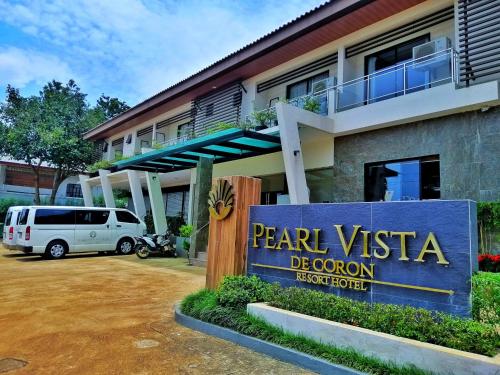 un panneau devant un bâtiment avec une camionnette devant dans l'établissement Pearl Vista de Coron Resort Hotel, à Coron