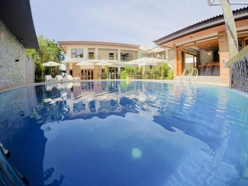 une grande piscine devant une maison dans l'établissement Pearl Vista de Coron Resort Hotel, à Coron