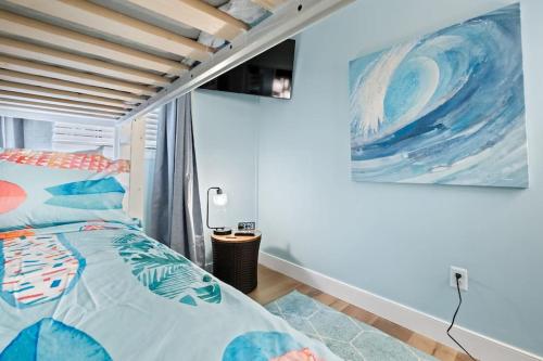 una camera da letto con un letto e un quadro sul muro di Just Beachy a Hilton Head Island